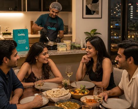 Friends at a dinner party with a Qwikly chef cooking in the kitchen